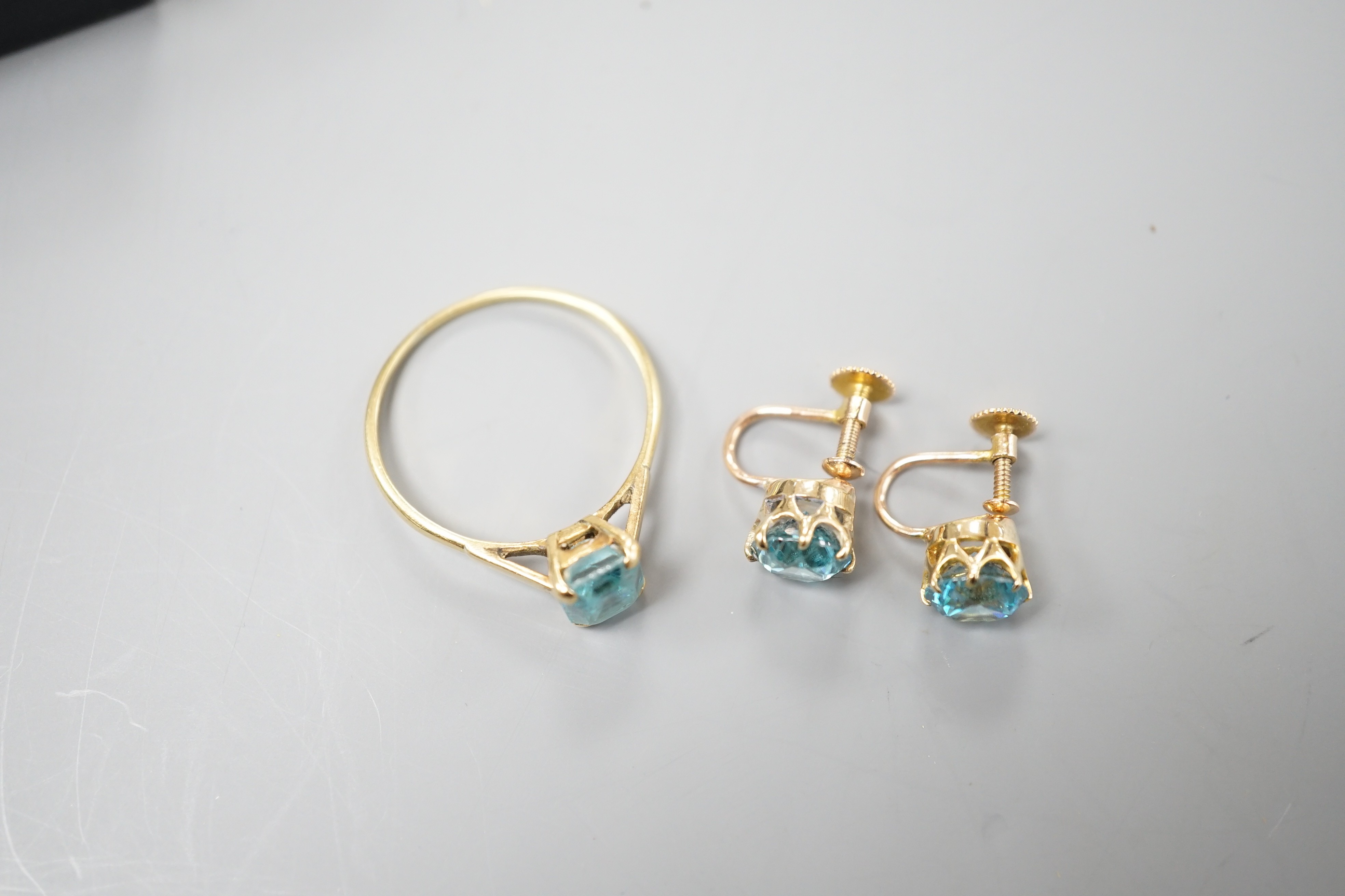 A pair of yellow metal and blue zircon ear clips and a yellow metal and paste set ring, gross weight 5 grams.